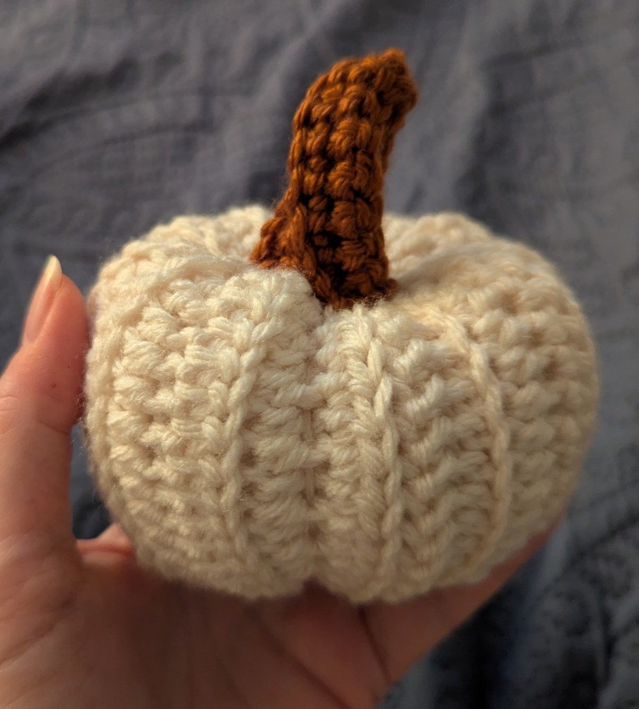 crocheted pumpkin held in hand